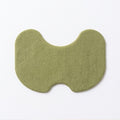 Un parche para rodilla verde de frente sobre fondo blanco, con su forma de reloj de arena.