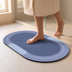 Pies descalzos pisando la alfombra de baño azul al salir de la ducha.