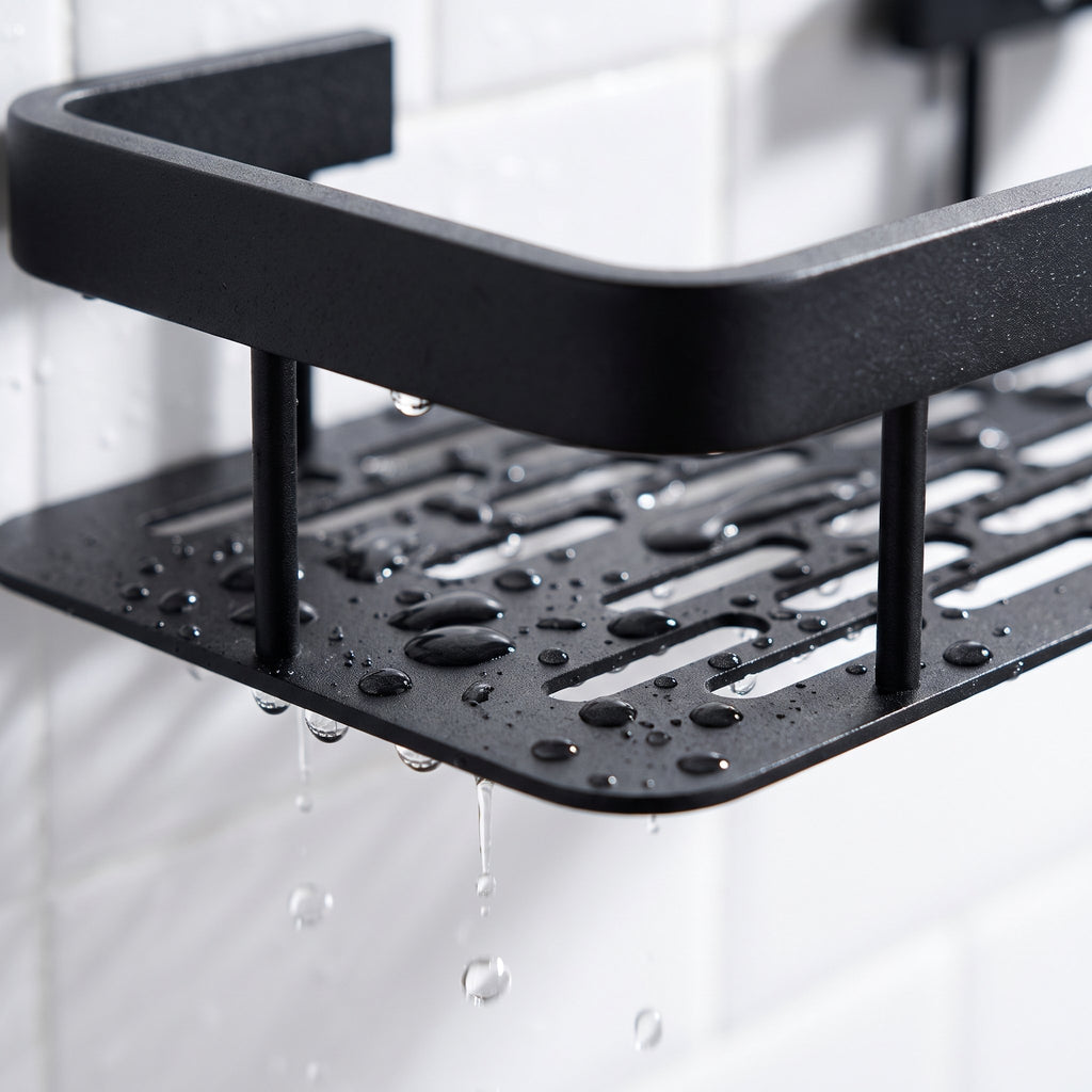 Gotas de agua escurriendo por las ranuras de la base de la repisa de aluminio negro.