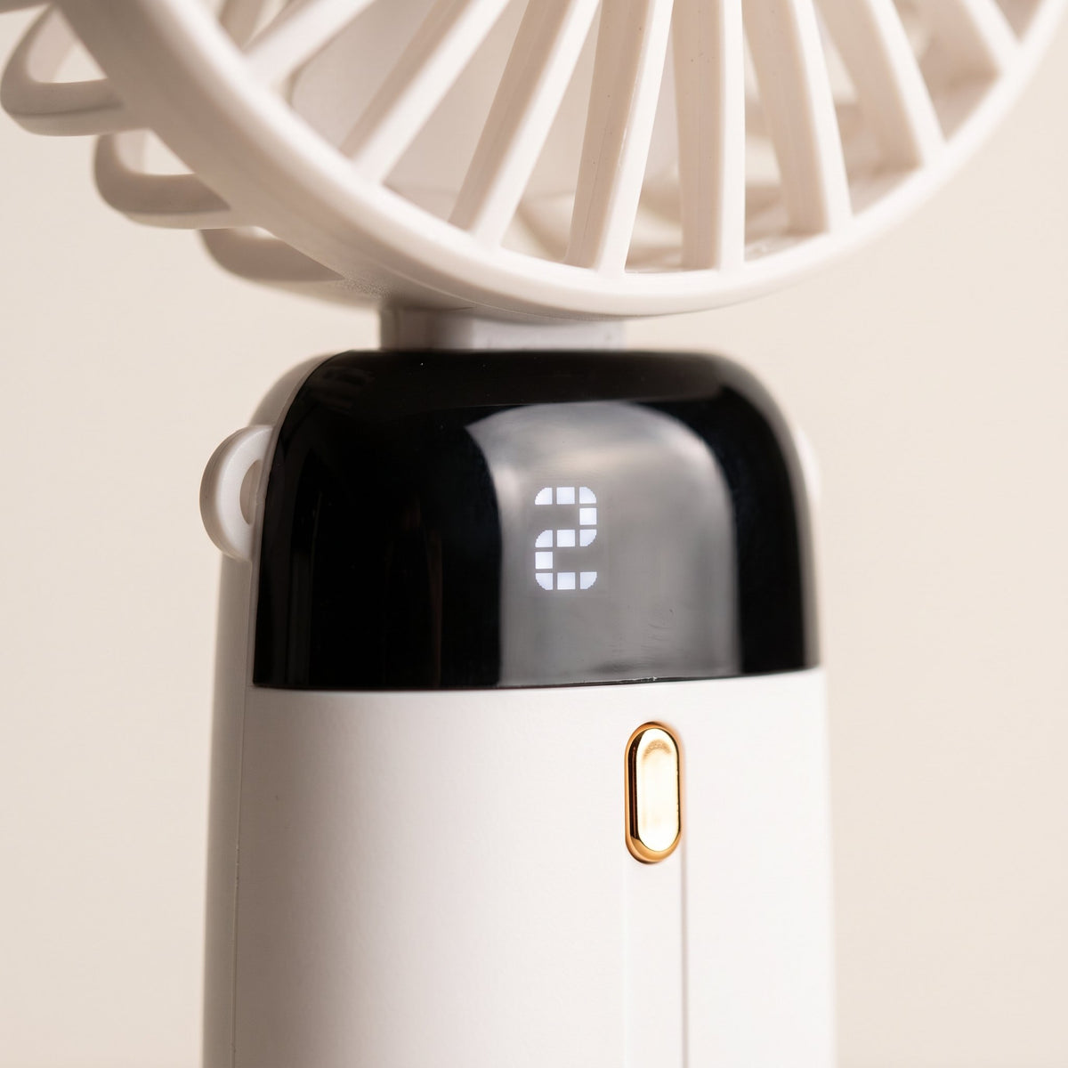 Detalle de la pantalla negra con un dígito y el botón de borde dorado del ventilador.