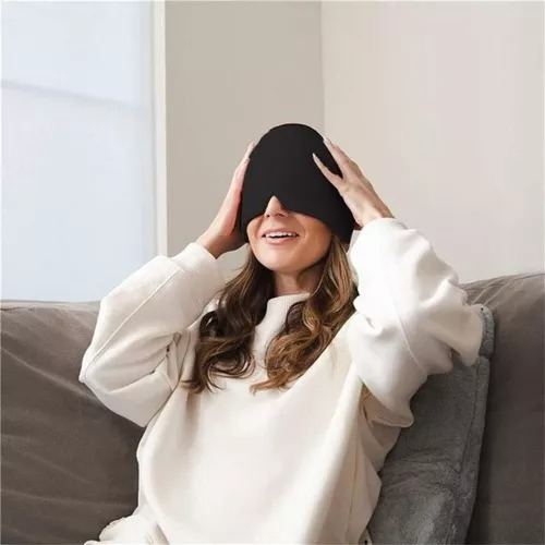 Mujer en un sofá sujetando con las dos manos el gorro de gel sobre sus ojos.